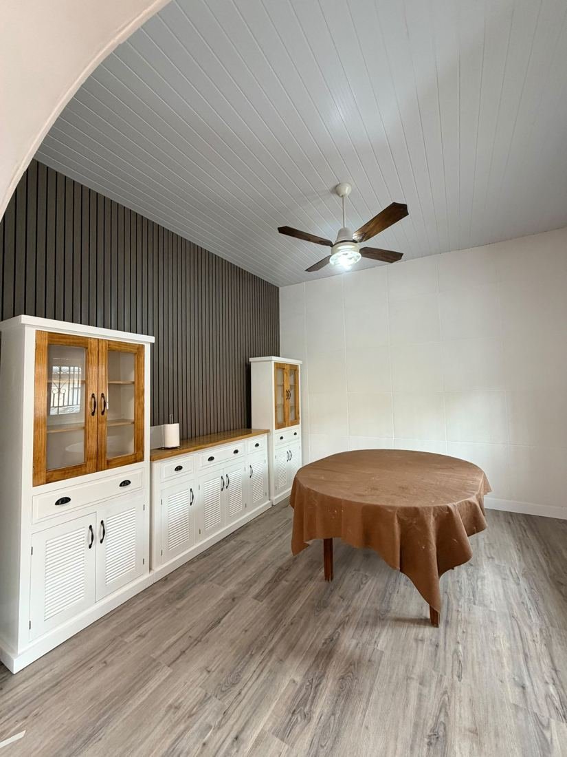 Comedor con wallpanel, cielorraso de PVC y piso símil madera gris