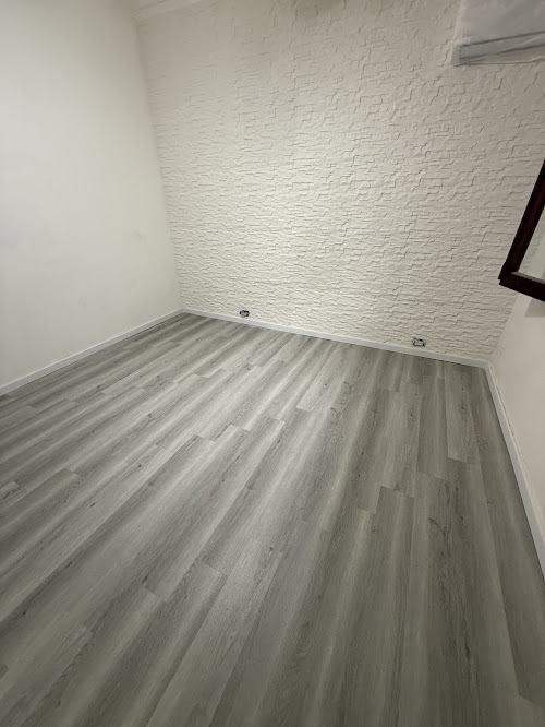 Piso SPC gris símil madera y pared símil piedra blanca